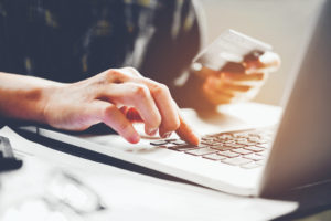 Person sitting at computer paying their bill online